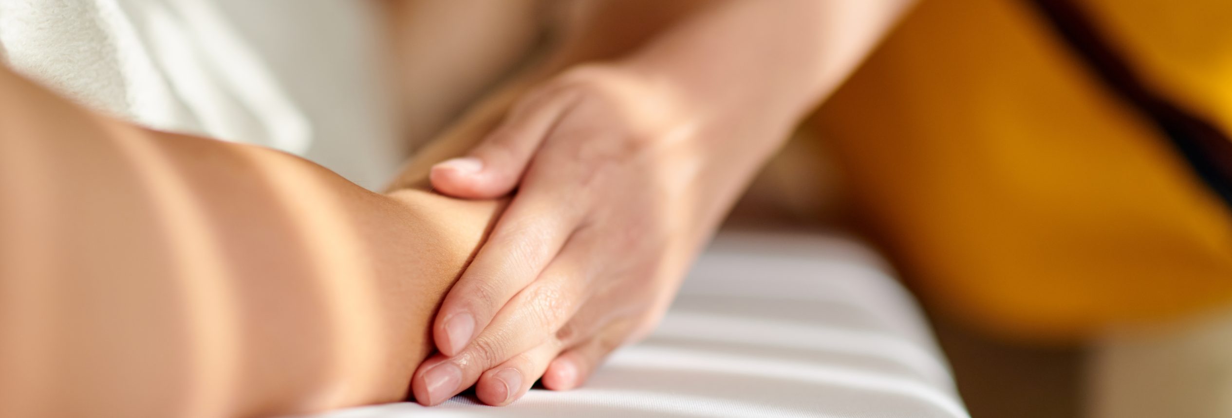 Sanfte Berührung während einer craniosacralen Sitzung auf der Liege